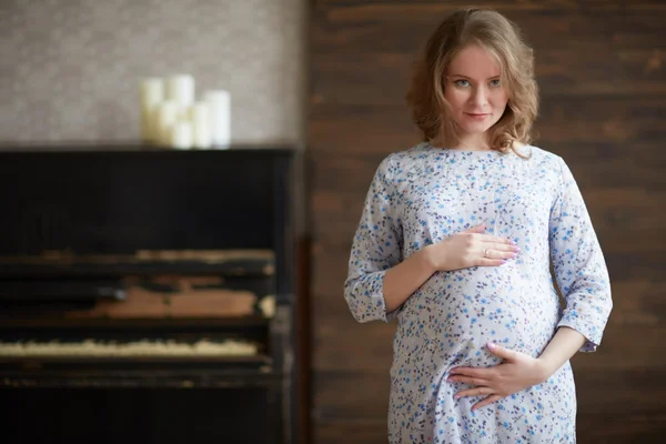 Mujer embarazada cerca de piano —  Fotos de Stock