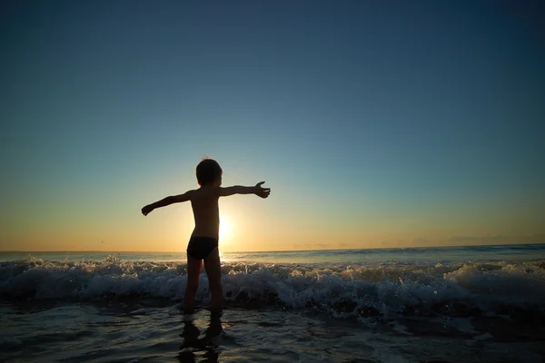 Boy playing on beach at sunset — Stock Photo, Image