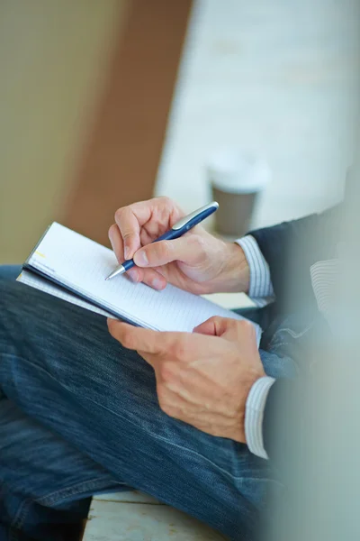 Hombre de negocios escribiendo en cuaderno — Foto de Stock