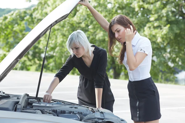 women near broken car