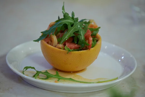 Salad in grapefruit peel with arugula — Stock Photo, Image