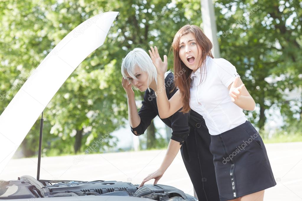 Young women near broken car 