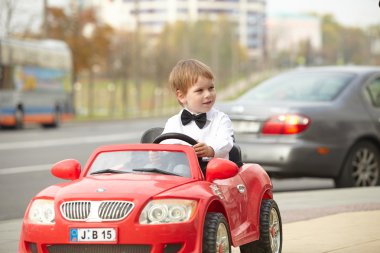 Küçük çocuk araba kullanıyor.