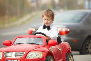 Küçük çocuk araba kullanıyor.