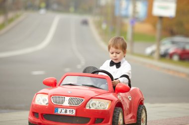 Küçük çocuk araba kullanıyor.