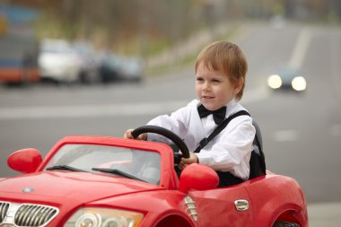 Küçük çocuk araba kullanıyor.