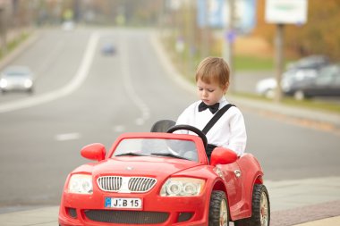Küçük çocuk araba kullanıyor.