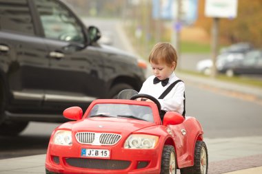 Küçük çocuk araba kullanıyor.