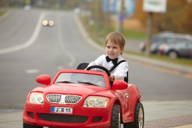 Küçük çocuk araba kullanıyor.