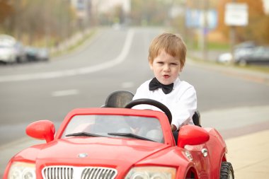 Küçük çocuk araba kullanıyor.