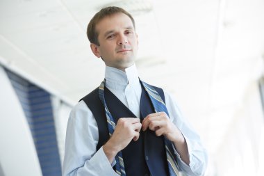 Businessman tying his tie clipart