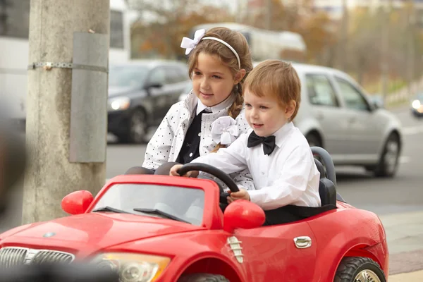 Девочка и мальчик в красной машине — стоковое фото
