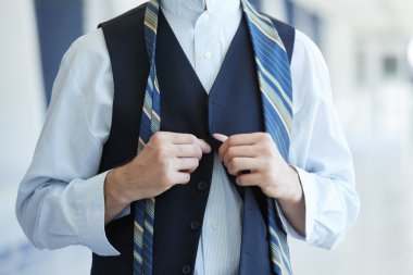 Businessman tying his tie clipart