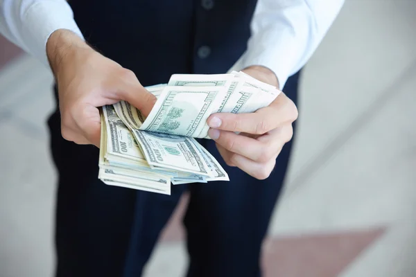 Доллары в руках бизнесмена — стоковое фото