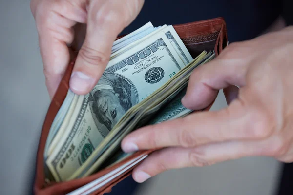 Man holding purse with money — Stock Photo, Image