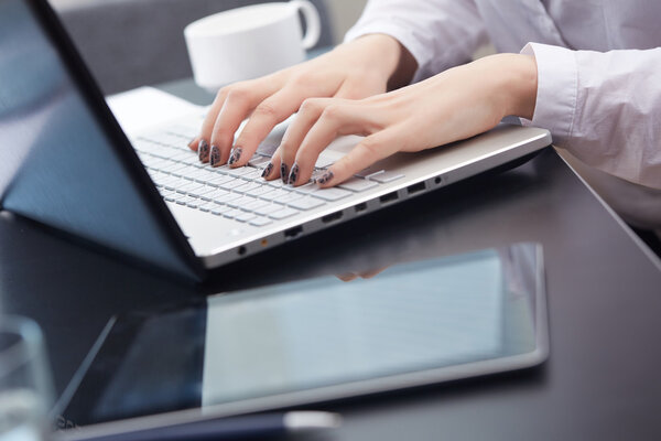 Businesswoman typing on laptop