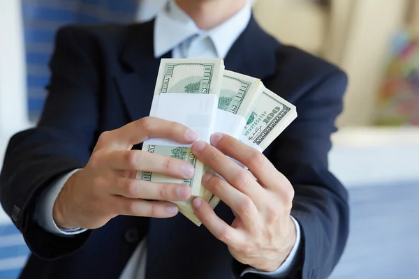 Доллары в руках бизнесмена — стоковое фото
