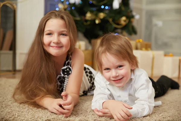 Chica y niño cerca del árbol de Navidad —  Fotos de Stock