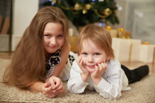 Chica y niño cerca del árbol de Navidad —  Fotos de Stock