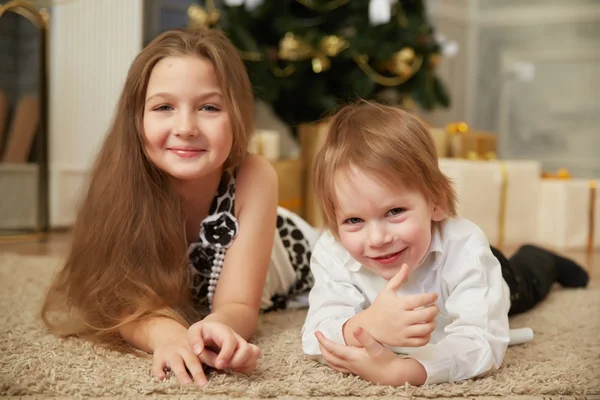 Chica y niño cerca del árbol de Navidad —  Fotos de Stock