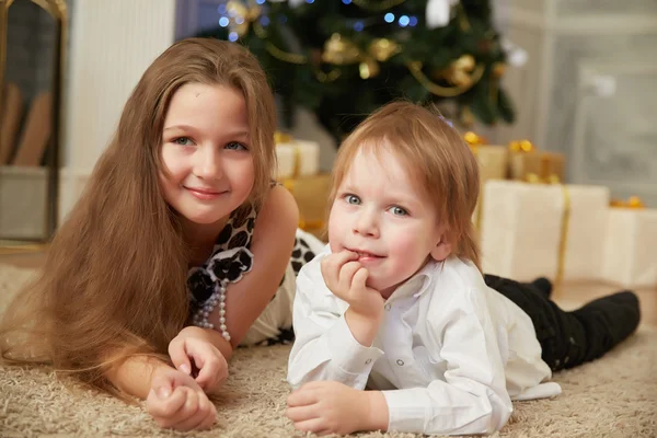 Chica y niño cerca del árbol de Navidad —  Fotos de Stock