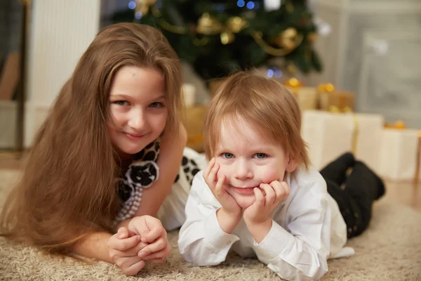 Chica y niño cerca del árbol de Navidad —  Fotos de Stock