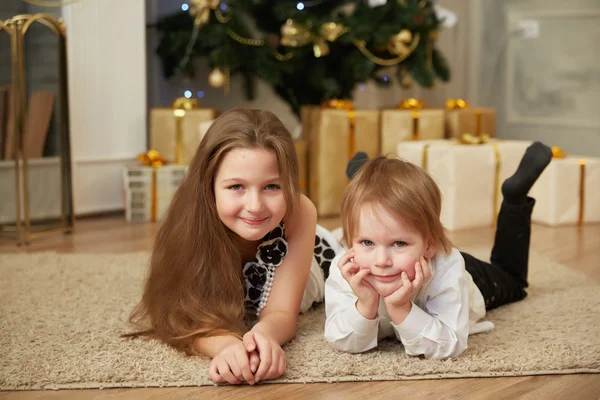 Chica y niño cerca del árbol de Navidad —  Fotos de Stock