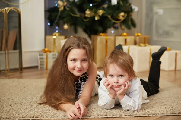 Chica y niño cerca del árbol de Navidad —  Fotos de Stock