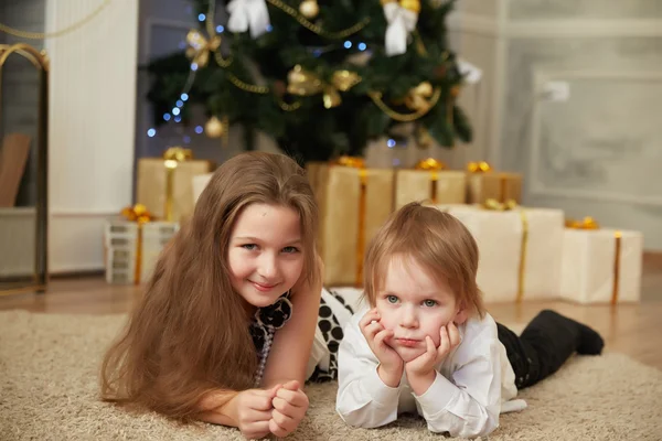 Chica y niño cerca del árbol de Navidad —  Fotos de Stock