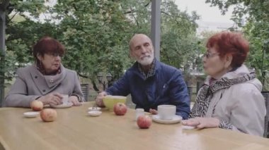 Emeklilerden oluşan zarif bir grup birlikte oturup çay içiyor.