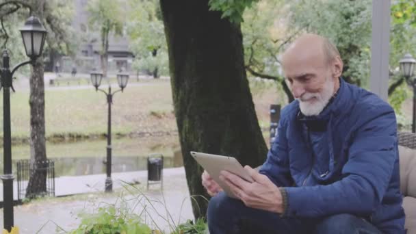 Hombre en elegante chaqueta azul marino se desplaza moderno tableta pantalla — Vídeo de stock