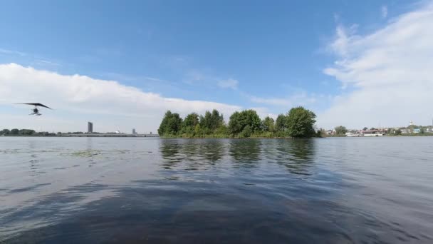 Nowoczesny biały paralotnia lata nad powierzchnią rzeki Daugava — Wideo stockowe