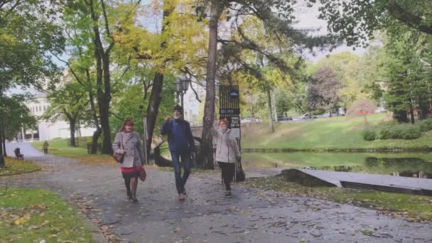 Бородатый пенсионер гуляет с элегантными подругами в парке — стоковое видео