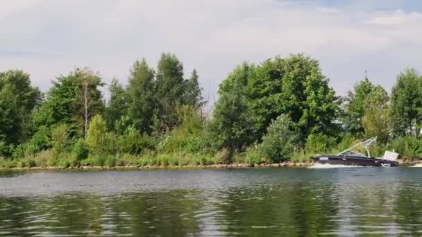 Μαύρο μηχανοκίνητο σκάφος πλέει γρήγορα περνώντας από το νησί του ποταμού Daugava — Αρχείο Βίντεο