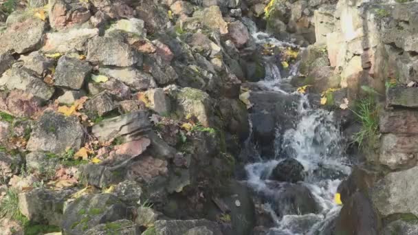 Pequena cachoeira corre para baixo entre grandes pedras marrons pilha — Vídeo de Stock