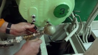 Vatman elleri vidaları gevşetiyor İngiliz anahtarıyla tanker pompasında