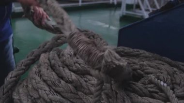 Denizci, yeşil petrol tankeri güvertesinde demirleme hatları topluyor