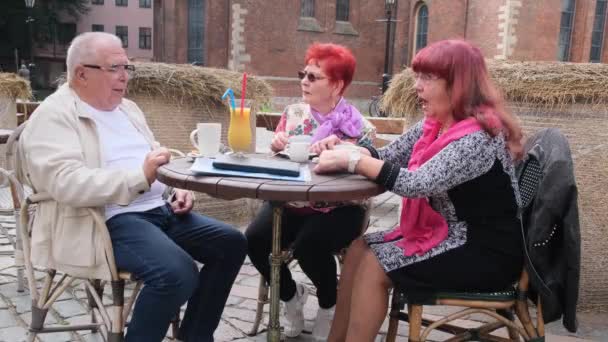 나이든 남자와 장성 한 여자들이 시내 카페에서 식탁에서 이야기 한다 — 비디오