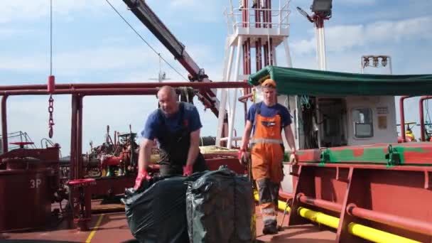Petrolero marineros en monos llevar productos a bordo — Vídeo de stock