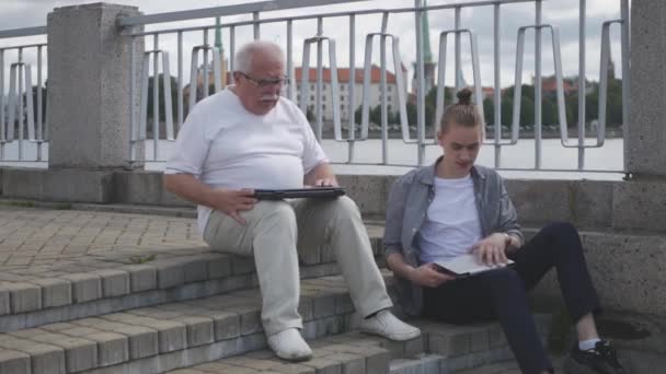 Unge og gamle mænd sidder på trin begynder at arbejde på gelændere – Stock-video