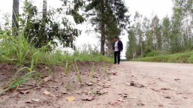 Çubuklu adam ağaçlara karşı mantar arıyor.