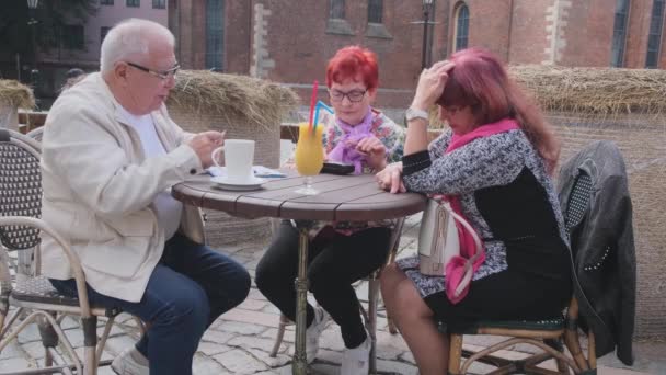 Mulher madura abre caso com óculos à mesa com amigos Vídeo De Stock Royalty-Free