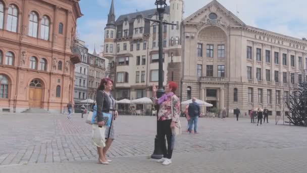 Mulheres sênior conversam de pé perto da luz da rua na praça da cidade Vídeo De Stock Royalty-Free