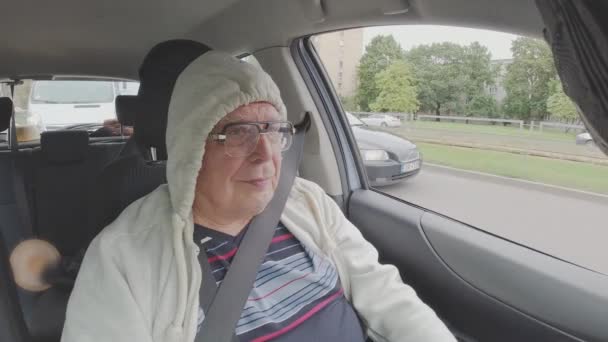 眼鏡のシニア男は車を運転し、フードアップを取ります ロイヤリティフリーストック映像