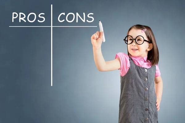 Linda niña con vestido de negocios y escribir pros y contras concepto de comparación. Fondo azul . —  Fotos de Stock