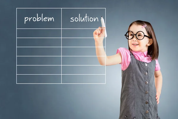 Linda niña con vestido de negocios y problema de escritura y lista de soluciones en blanco. Fondo azul . — Foto de Stock