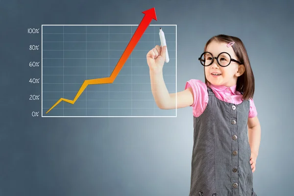 Söt liten flicka klädd företag klänning och skriva över prestationen graf. Blå bakgrund. — Stockfoto