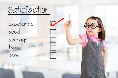 Sevimli küçük kız iş elbisesi giyen ve müşteri memnuniyeti anket formunda mükemmellik kontrol. Ofis arka planı.