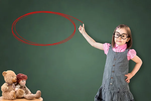 Nettes kleines Mädchen im Businesskleid und zeigt Kreis auf grünem Kreidebrett. — Stockfoto