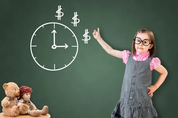 Schattig klein meisje dragen Business jurk en het tonen van een tijd concept op groene Chalk Board. — Stockfoto